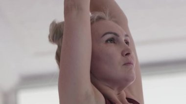 Women doing yoga in the light studio. Mid shot