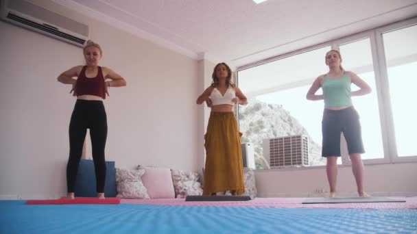 Yoga Class Three Women Standing Mats Moving Arms Mid Shot — Vídeo de Stock