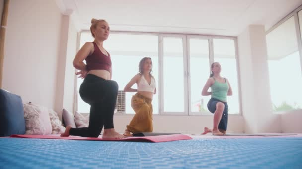 Three Women Standing Yoga Mats Knees Doing Exercises Studio Mid — 图库视频影像