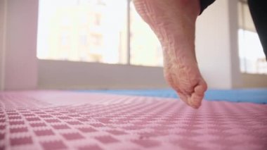 Two women walks in the studio and brings yoga mats with them. Mid shot