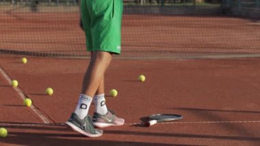 24-05-2022 TURKEY, ANTALYA: A young man forcefully hits a ball picked up from a tennis court with a racket. Mid shot