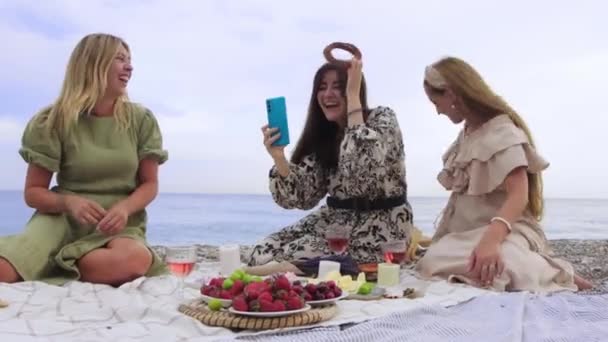 Забавні Жінки Беруть Селфі Бубликами Пляжі Маючи Пікнік Середній Постріл — стокове відео