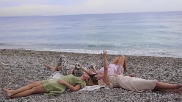 Four Female Friends Resting Sea Lying Head Blanket Mid Shot — Stockvideo