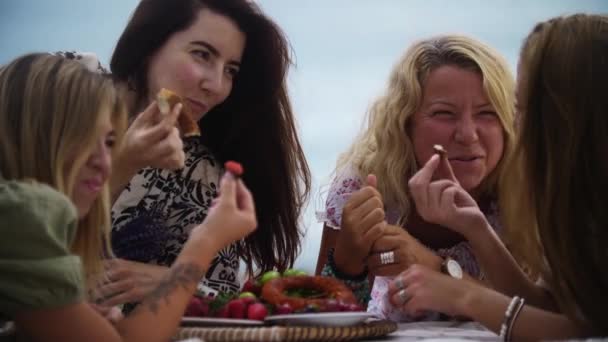 Чотири Жінки Які Мають Пікнік Біля Моря Їдять Фрукти Ковдрі — стокове відео