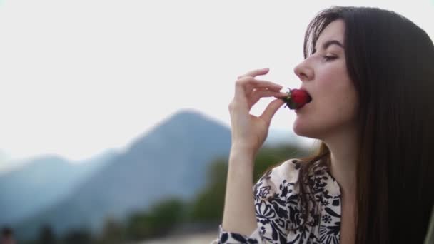 Brunette Woman Eating Strawberry Nature Mid Shot — Stockvideo
