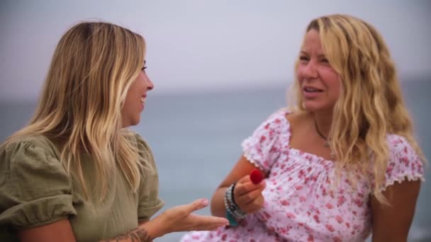 Two Female Friends Eating Strawberries Talking Beach Mid Shot — 图库视频影像