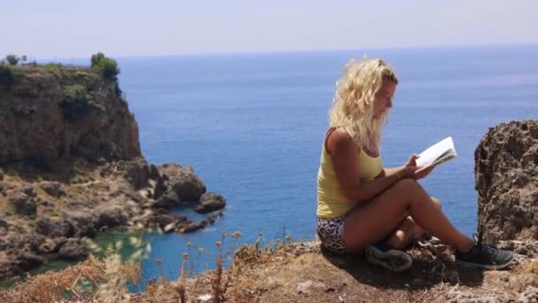 Woman Reads Book Cliff Edge Sea Mid Shot — Video