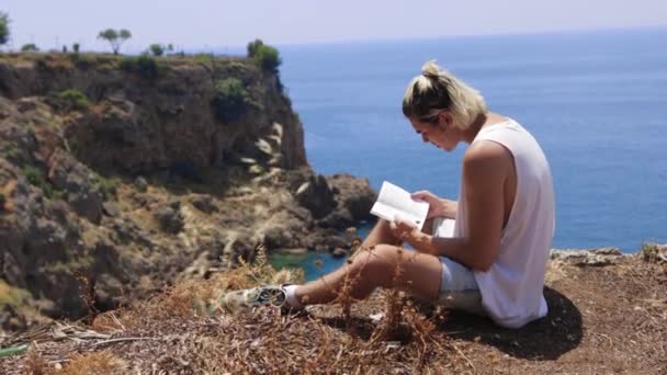 Young Man Dyed Hair Reading Book Cliff Edge Mid Shot — Stock Video