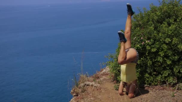 Woman Stands Yoga Position Her Head Upside Edge Cliff Moving — Vídeo de Stock