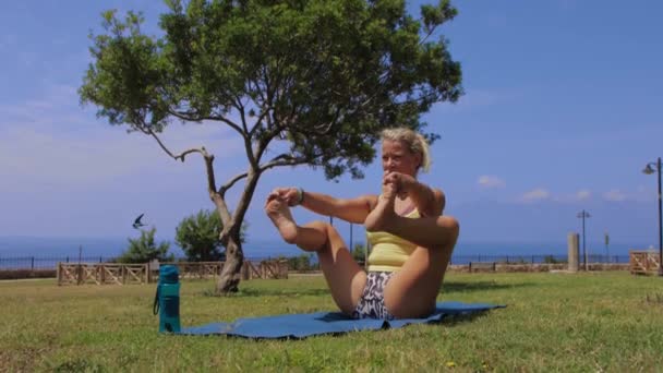 Μια Ενήλικη Γυναίκα Που Κάνει Γιόγκα Στη Φύση Κάνει Ασκήσεις — Αρχείο Βίντεο