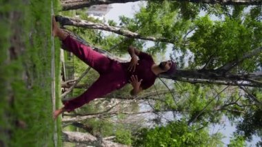 An arabian man runs a yoga practice in a park. Mid shot