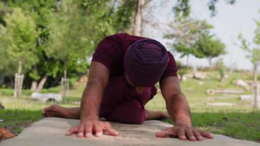 An arabian man sitting with his legs tightly crossed while yoga practice. Mid shot