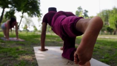 An arabian man doing yoga - stands on a yoga mat and shakes his leg. Mid shot