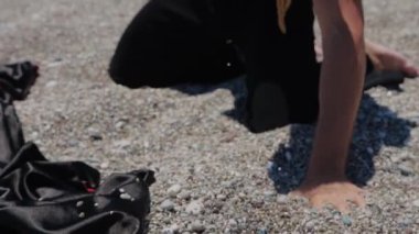 Sahne kostümlü çekici bir adam yumruğuyla çakıl taşlarını kavrıyor. Orta çekim