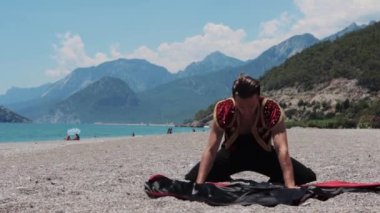 Sahne kostümü giymiş çekici bir adam gösterisini kumsalda sergilemeye başlar. Orta çekim