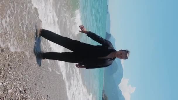 Genadige Aantrekkelijke Man Zwarte Kleren Met Blote Voeten Aan Kust — Stockvideo