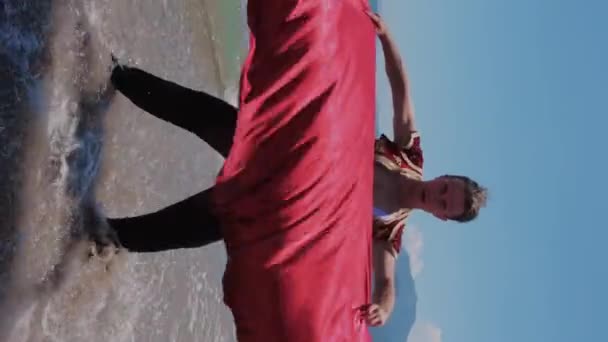 Ελκυστικός Χορευτής Που Κουνάει Κόκκινο Μανδύα Στην Ακτή Μεσαίο Πλάνο — Αρχείο Βίντεο