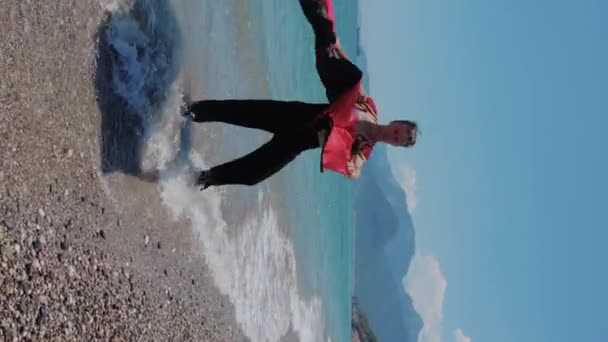 Ελκυστικός Χορευτής Που Κουνά Χέρι Του Κόκκινο Μανδύα Στην Ακτή — Αρχείο Βίντεο