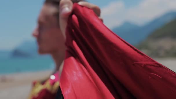 Atraktivní Muž Španělském Obleku Stojí Moře Drží Červené Roucho Střední — Stock video