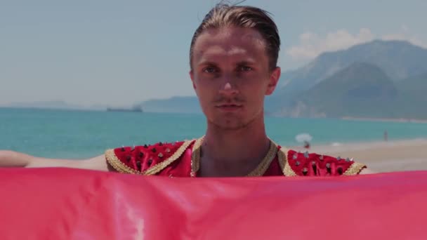 Приваблива Людина Національному Костюмі Стоїть Пляжі Тримає Червону Мантію Середній — стокове відео