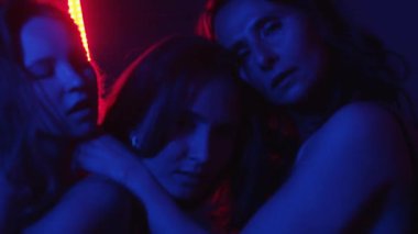 Üç seksi kadın neon ışıklı özel odada erotik şov yapıyor. Orta çekim