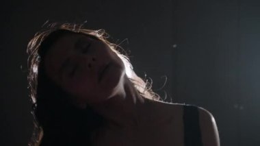 Karanlık odada seksi davranan esmer kadının yüzü. Portre