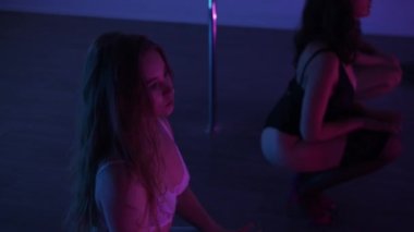 Ayna stüdyosunda neon ışıkla striptiz yapan üç farklı yaşta seksi kadın. Orta çekim