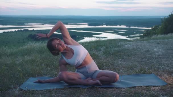 Slim Adult Woman Sitting Yoga Mat Hill Stretching Her Body — Stock Video