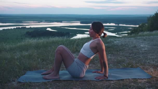 Een Slanke Vrouw Oefent Een Heuvel Een Yogamat Tussenschot — Stockvideo