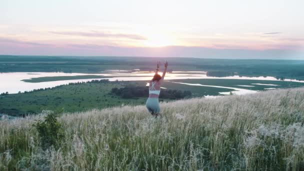 日落时分站在山上做瑜伽练习的活泼女人 — 图库视频影像