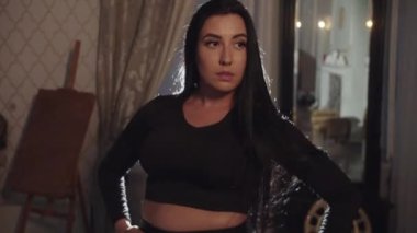 Odada siyah uzun saçlı, oryantal dans yapan bir kadın. Orta çekim