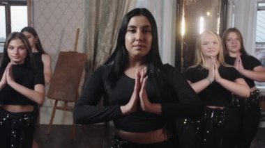 Bir grup genç kız öğretmenlerinin arkasındaki sıranın kenarına dağılır ve oryantal bir dans etmeye başlar. Orta çekim