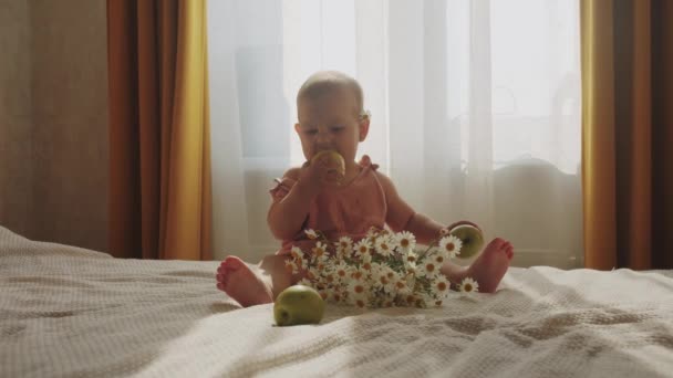 Маленькая Девочка Сидит Кровати Маргаритками Яблоками Средний Выстрел — стоковое видео