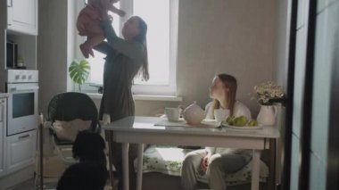 İki odalı bir dairede bir anne ve iki kızlı bir aile. Orta çekim