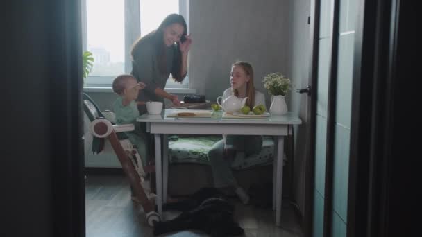 年轻的母亲把蛋糕放在桌上给女儿们吃 — 图库视频影像