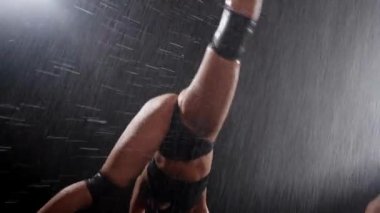 Two sexy young women dancing seductive dancing in the rain and shaking their ass. Mid shot
