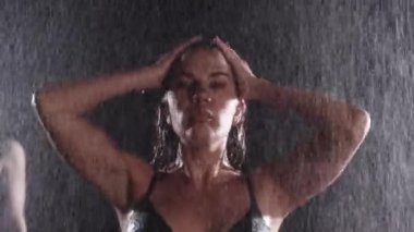 Yağmurun altında karanlık odada duran seksi kadın dansçı. Portre