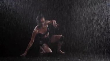 Siyah iç çamaşırlı, yağmurun altında dans eden güzel vücutlu seksi kadın. Orta çekim