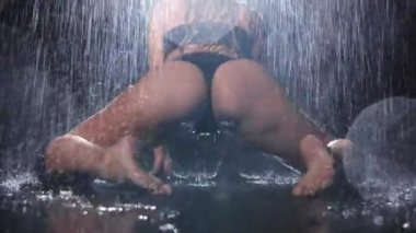 Hot young woman with nice body in black underwear shaking her ass under the rain. Mid shot