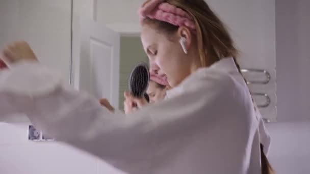 Mladá Žena Tančí Koupelně Bezdrátových Sluchátkách Zpívá Hřebenu Kamera Hlediskem — Stock video