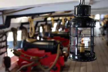 Tarihsel retro metal el feneri savaş gemisindeki topun önünde - güvertede durun