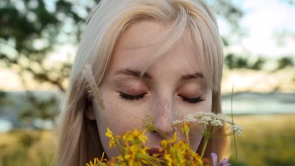 Eine Schöne Blonde Junge Frau Mit Grünen Augen Hält Blumen — Stockvideo