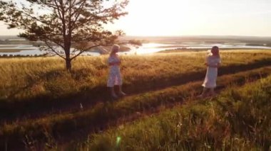 Sahada randevusu olan yaz ışığı elbiseli iki genç sarışın kadın. Hava görünümü