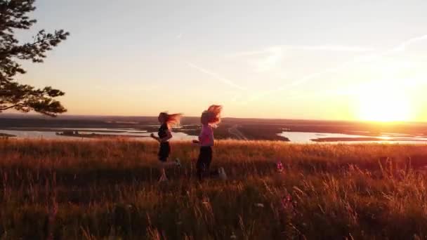Två Unga Atletiska Kvinnor Joggar Kullen Ovanför Motorvägen Vid Solnedgången — Stockvideo