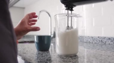 Bir kadın krema kabına şeker şurubu döküp şeker tozu ekliyor. Orta çekim