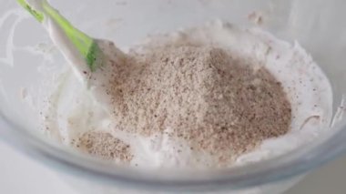 Pasta için beyaz kremayı tatlı şekerlerle karıştıran bir kadın fırıncı. Orta çekim