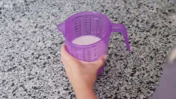容器にホットミルクを飲み込む女性 ミッドショット — ストック動画