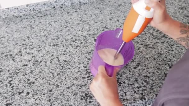 台所の容器に熱い牛乳を泡立てる女性 ミッドショット — ストック動画