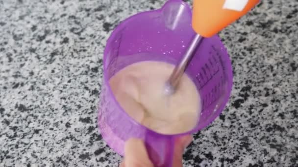 台所の容器にライトピンクのホットミルクをむいた女性 ミッドショット — ストック動画