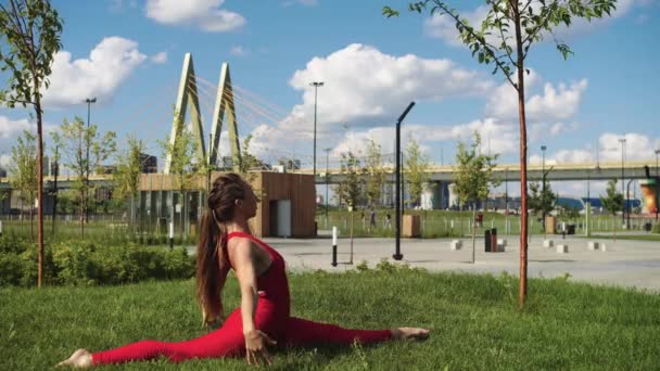 一个穿着红色训练服的女人在室外做瑜伽 坐在裂缝上 — 图库视频影像